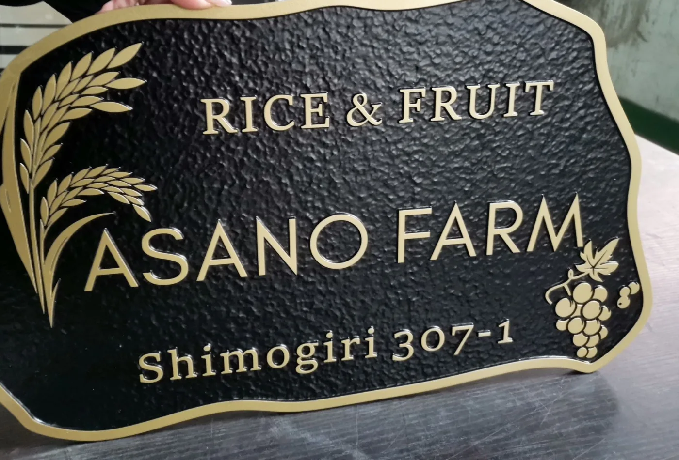 Shaped embossed business plaque with forged texture and raised wheat and grape emblems